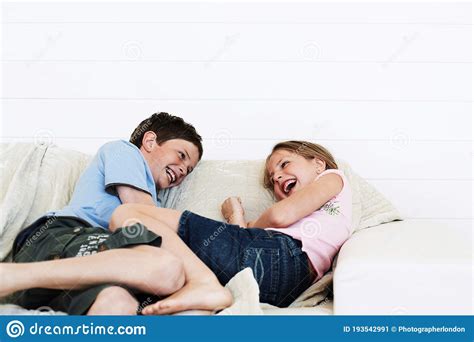 Brother And Sister Relaxing On Sofa Together Stock Image Image Of
