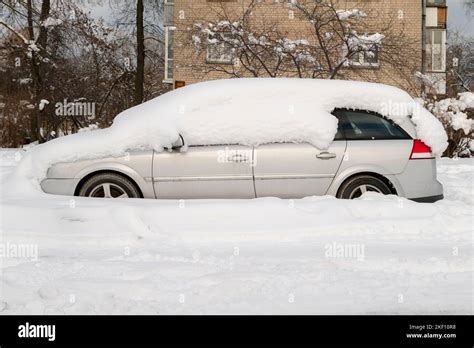 Car Covered With Thick Layer Of Snow Automobile After Snowstorm Parked