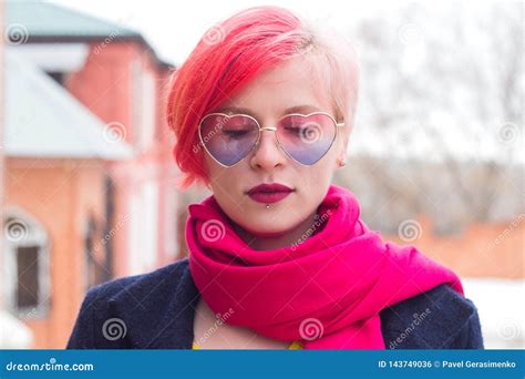 Portrait Of An Attractive Young Woman With Colored Hair And Piercing Under Her Lip Glasses