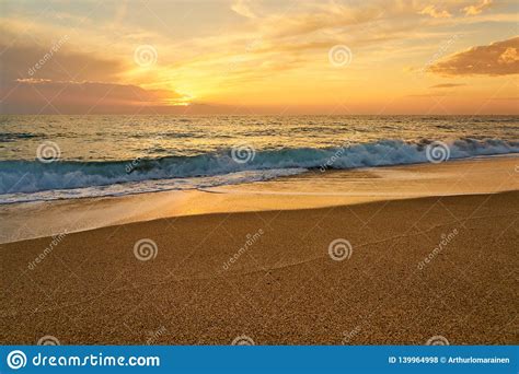 Colorful Sunset At The Tropical Sandy Beach Waves With Foam Hitting