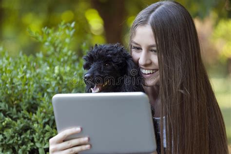 The Young Beautiful Woman Holds Her Dog And Together Looking Stock