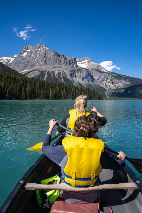 Two Women Paddle On A Canoe On Emerald Lake In Yoho National Park