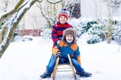 Two Little Kid Boys Enjoying Sleigh Ride In Winter Stock Photo Image
