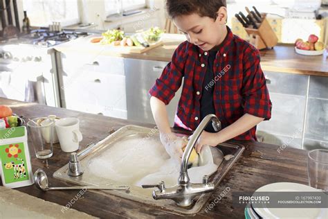 Menino Lavando Louça Pratos Na Cozinha — Infância Em Casa Stock