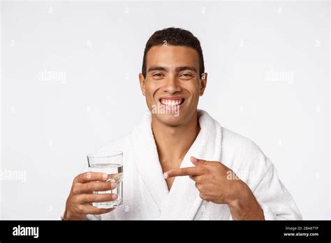 An Attractive Man Drinking A Glass Of Water Against White Background