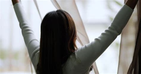 Young Woman Opens Curtain And Looks Out Of Window Stock Footage
