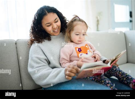 babysitter black woman read book with little child girl Stock Photo - Alamy