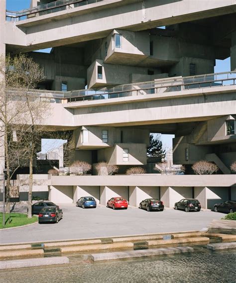 Several Cars Parked In Front Of A Building With Balconies