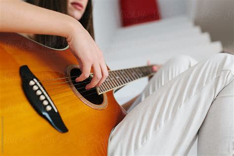 Woman Playing Acoustic Guitar At Home By Stocksy Contributor VICTOR