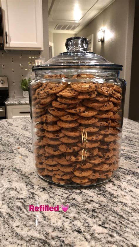 A Glass Jar Filled With Cookies On Top Of A Counter