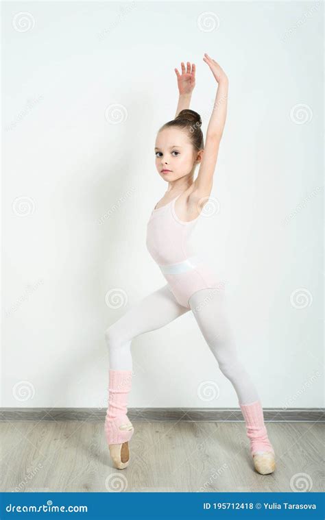 A Little Adorable Young Ballerina Does Ballet Poses And Stretching