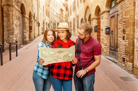 Grupo De Amigos Turistas Mirando El Mapa De Una Ciudad Vieja En Italia