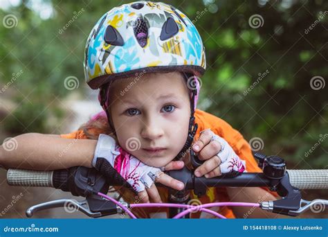 Nettes Kleines Trauriges Mdchen In Einem Sturzhelm Mit Einem Fahrrad