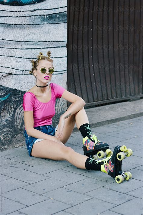 Girl In Roller Skates Sitting On The Street By Stocksy Contributor