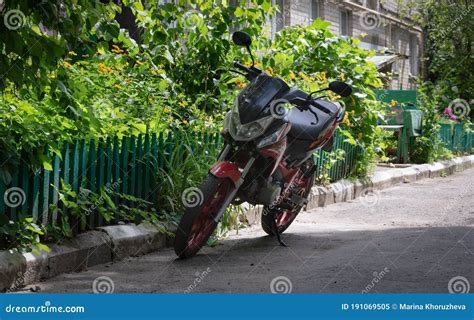 Motorcycle Parked Near The Front Garden Of The House Stock Image
