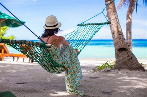 Joven Mujer Tumbada En La Hamaca En La Playa Tropical Foto Premium