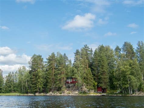 A Typical Scandinavian Red Wooden Cottage On The Shores Of Lake Saimaa