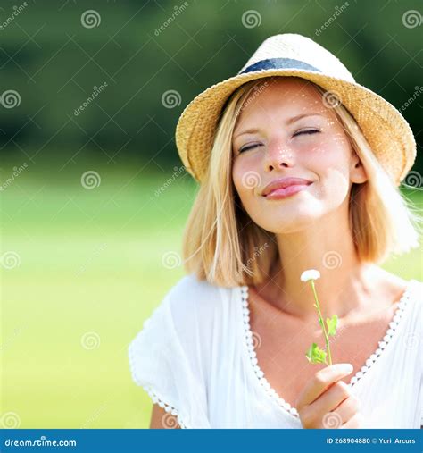 Appreciating The Beauty Of Nature Pretty Young Woman Wearing A Hat And Smiling While Holding A