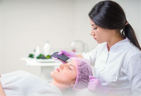 Hands Of Cosmetologist Making Ultrasound Facial Cleaning With Special