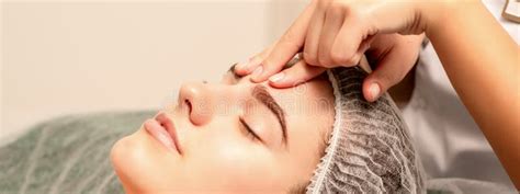 Beautiful Caucasian Young Woman Receiving A Facial Massage With Closed Eyes In Spa Salon Close