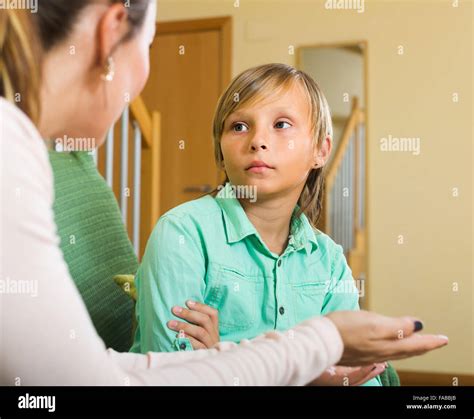 Serious Mother Scolding Naughty Teenage Son In Home Interior Stock