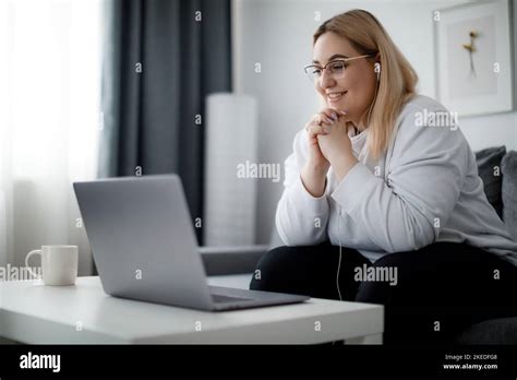 Smiling Young Female Student With Extra Weight Sitting On Comfy Couch
