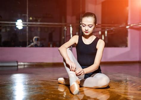 Premium Photo Young Ballerina In Black Body Sitting Down And Tying Pointe Ballet Shoes On