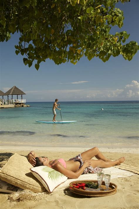 tanning on the beautiful beaches of jamaica with a cocktail sandalsgranderiviera sandals ochi