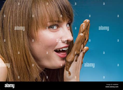 Femme de lécher le chocolat fondu à partir de sa main couverte de chocolat Photo Stock Alamy