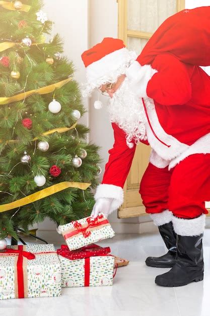 Santa Claus Putting Presents Under Fir Tree Photo Free Download