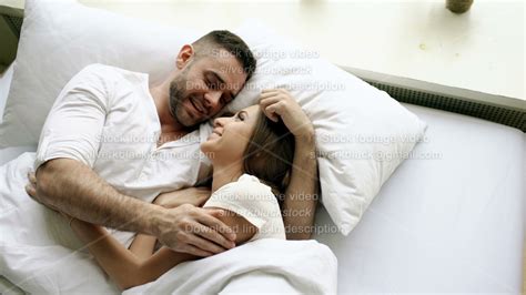 Young Beautiful And Loving Couple Talk And Hug Into Bed While Waking Up In The Morning Top View