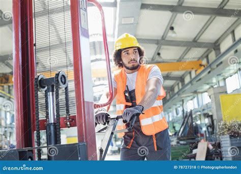 Young Manual Worker Pushing Hand Truck In Metal Industry Stock Photo