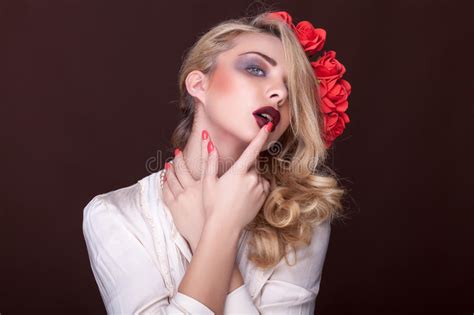 Чувственная женщина с пальцем на ее губах и цветках в голове Стоковое Фото изображение