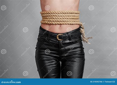 Slender Figure Of A Woman In Black Leather Pants Thick Cord Rope