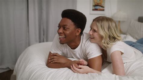 Young Interracial Couple In Love Caucasian Girlfriend Lying On Top Of