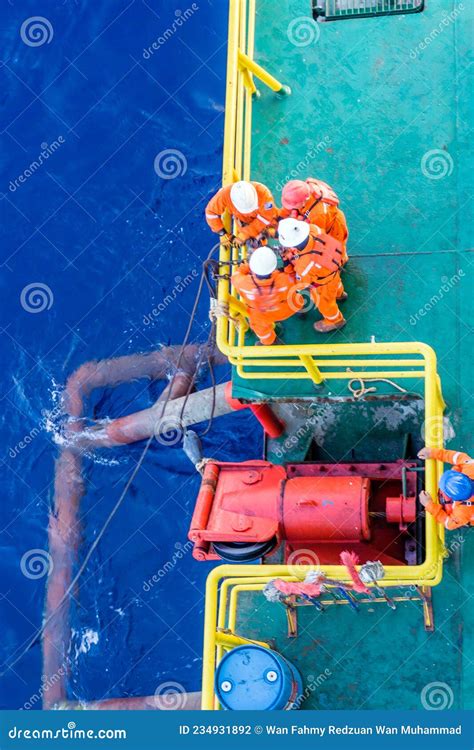 Riggers Working On Anchor Handling On A Construction Wok Barge At