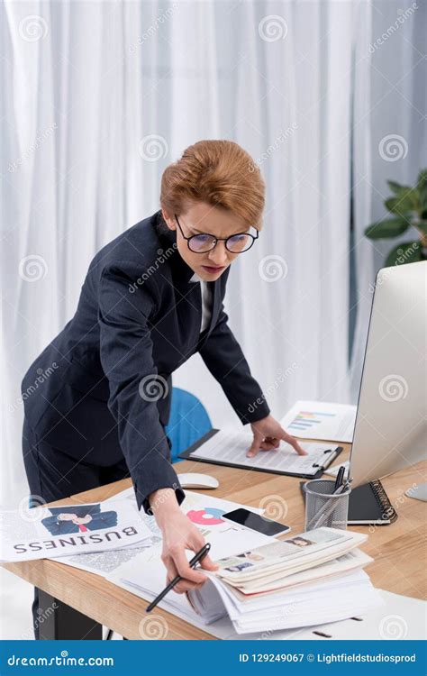 Concentrated Businesswoman Doing Paperwork At Workplace Stock Image