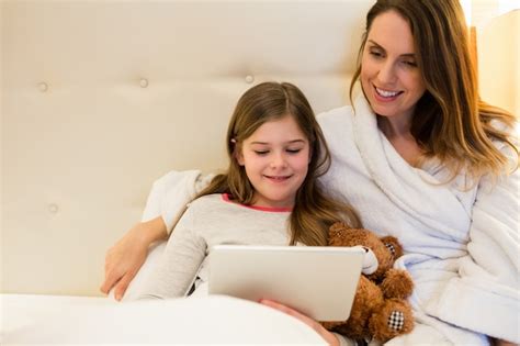 Madre E Hija Que Usa La Tableta Digital En El Dormitorio Descargar