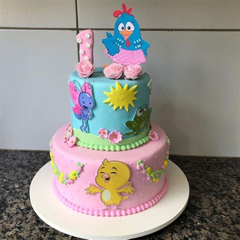 A Three Tiered Cake Decorated With Cartoon Characters And Numbers On It