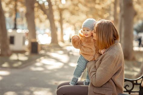 Mother And Child On A Walk In A Public Park Hugs And Kisses Stock