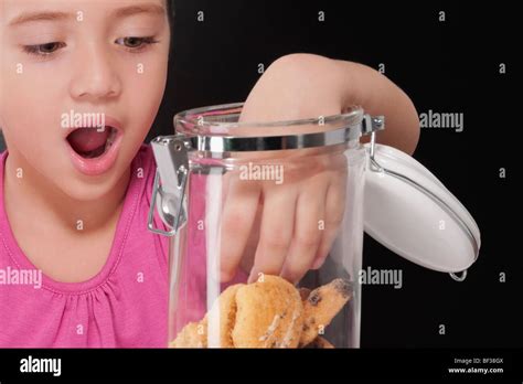 Girl Putting Her Hand Into A Cookie Jar Stock Photo Alamy