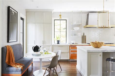 Bright White Kitchen With Pops Of Orange Brass Accents And Banquette