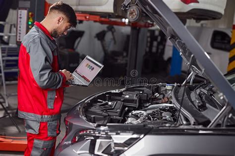 Mechanic Using Laptop And Inspecting Car In Service Stock Image Image