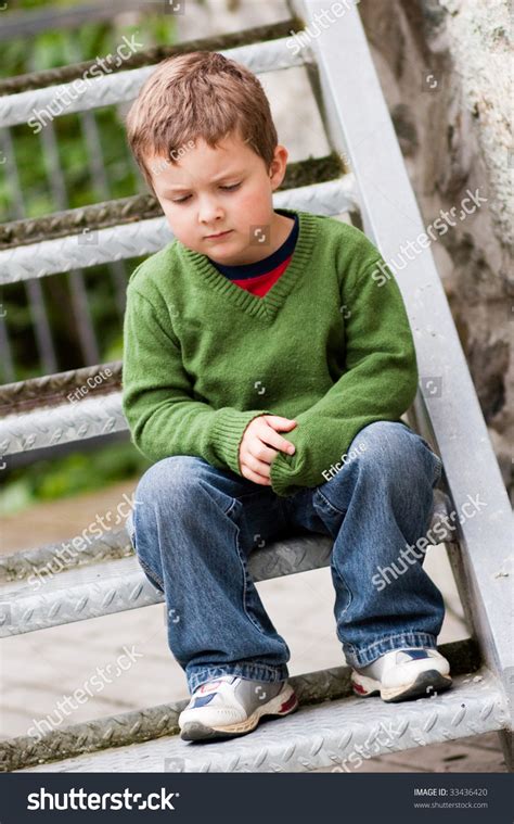 Sad Little Boy Sitting Alone On Stairs Stock Photo