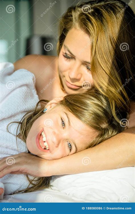 una madre y su hija se acostan en la cama foto de archivo imagen de princesa hermoso 188080086