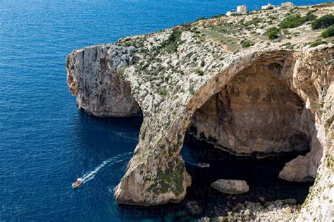 Boats Of Tourists Visiting The Dramatic Natural Arch At The Blue Grotto
