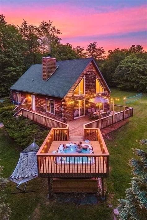 An Aerial View Of A Cabin With Hot Tub And Deck At Sunset Or Sunrise Time