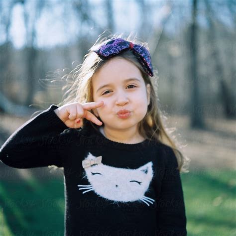 Cute Young Girl Making A Duck Face And A Sign With Her Hand By Stocksy Contributor Jakob