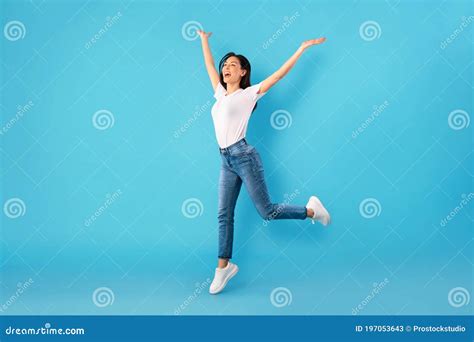 Happy Woman Jumping Over Blue Studio Wall Stock Image Image Of Mood