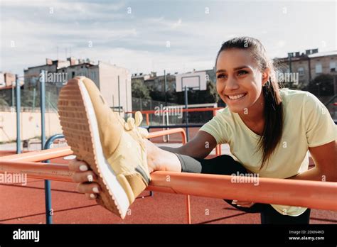 Cheerful Woman Stretching Legs On Sport Ground Stock Photo Alamy